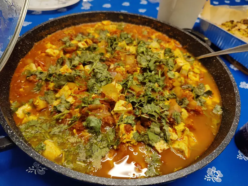 A pan of paneer curry with fresh coriander