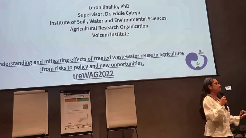 Leron, microphone in hand, presenting her PhD research at a scientific conference